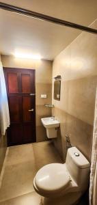 a bathroom with a toilet and a sink and a door at Sea View Balcony room - Tide End Beach Villa in Pallipuram