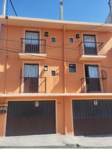 an orange building with two garage doors at Lofts en el Corazon de Coatepec Veracruz in Coatepec