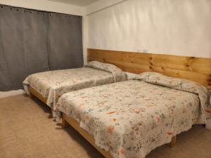 two beds sitting in a room with at Lofts en el Corazon de Coatepec Veracruz in Coatepec