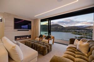 a living room with a fireplace and a large window at Northview Residence in Frankton
