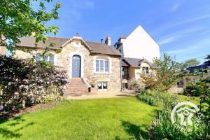 a large brick house with a white turret at Le cerisier in Cancale