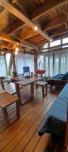 a large room with wooden floors and tables and windows at Torii Cabañas de Montaña in Villa Carlos Paz