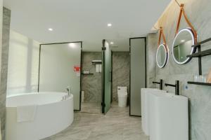 a bathroom with a tub and a sink and a toilet at city gezhi hotel in Guancun
