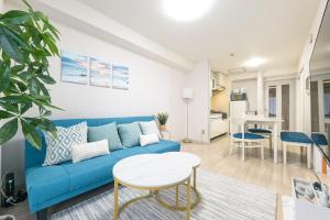 a living room with a blue couch and a table at Sapporo Residence 14 in Sapporo