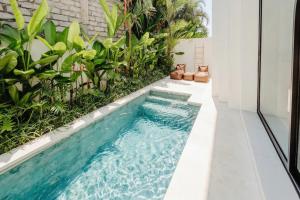 an infinity pool in the middle of a house with plants at Lily Villas - Rice Field Views Escape with Private Pool in Canggu +86 photos