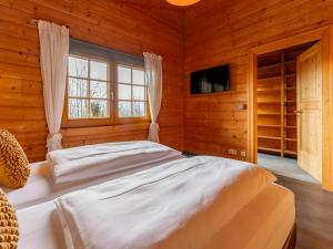 a bedroom with a large bed in a wooden room at TraumLodge in Kleinsonnberg +46 photos