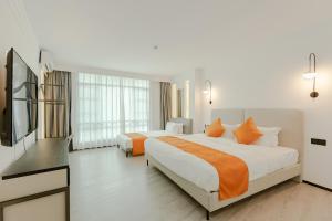 a hotel room with two beds and a flat screen tv at city gezhi hotel in Guancun