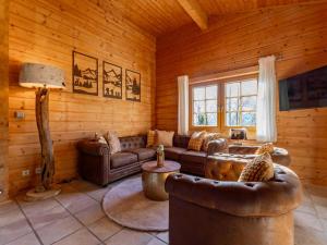 a living room with leather furniture in a log cabin at TraumLodge in Kleinsonnberg