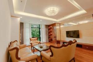a living room with a couch and a table and chairs at city gezhi hotel in Guancun