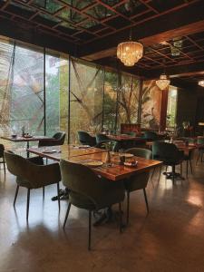 a dining room with tables and chairs and a chandelier at Lao Poet Hotel in Vientiane