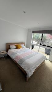 a bedroom with a large bed with a window at Weekend Escape in Rosebud