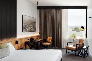 a hotel room with a bed and a desk and a window at Hotel Verge Launceston in Launceston +91 photos