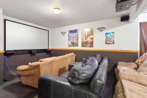 a living room with a couch and a projection screen at 6119 - Gone Coastal in Nags Head