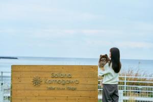 a woman holding a child standing next to a sign at Solana 鴨川 in Kamogawa