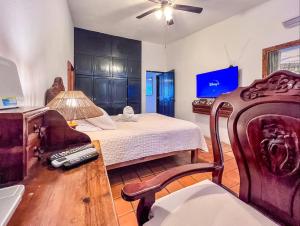 a bedroom with a bed and a chair and a fan at Casa Blanca Condominio in La Paz