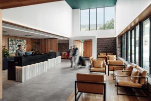 a lobby with a bar and chairs and windows at Hotel Verge Launceston in Launceston