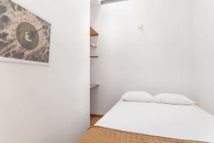 a small room with a bed and a picture on the wall at Goabio Apartment 3 Riverview in Porto