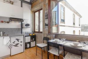 a kitchen with a table and chairs in a room at Goabio Apartment 3 Riverview in Porto