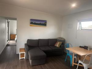 a living room with a couch and a table at Whangamata Bach Life in Whangamata