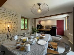 a dining room with a table and chairs and a kitchen at Maison du causit in Aubertin
