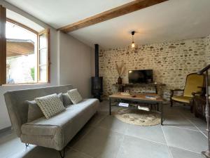 a living room with a couch and a table at Maison du causit in Aubertin