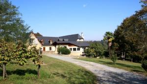 a large white house with a driveway at Maison du causit in Aubertin