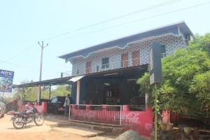 a building with a motorcycle parked in front of it at Harsh Guest House in Cola