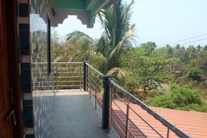 a balcony of a house with a view of trees at Harsh Guest House in Cola