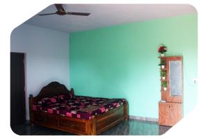 a bedroom with a bed and a blue wall at Harsh Guest House in Cola +5 photos