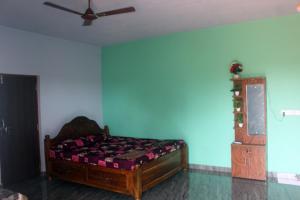 a bedroom with a bed and a ceiling fan at Harsh Guest House in Cola