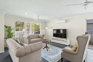 a living room with two couches and a tv at Comfortable 4BR Coomer Escape Close to Everything in Gold Coast