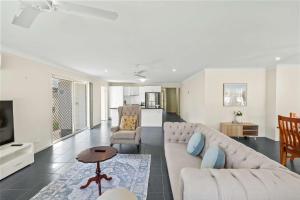 a living room with a couch and a table at Comfortable 4BR Coomer Escape Close to Everything in Gold Coast +33 photos