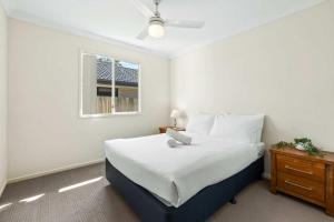 a bedroom with a bed with a laptop on it at Comfortable 4BR Coomer Escape Close to Everything in Gold Coast
