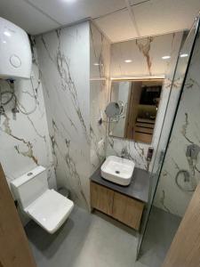a bathroom with a toilet and a sink and a mirror at LaCasa Heights in Greater Noida