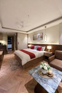 a bedroom with a large bed and a living room at LaCasa Heights in Greater Noida