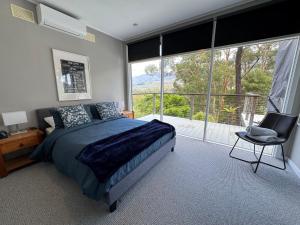 a bedroom with a bed and a large window at Sunset View House - Rustic Outdoor Bathhouse, Walk to Town in Warburton