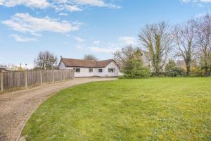 a yard with a white house and a fence at 2 Bed in Halesworth oc-dak in Halesworth