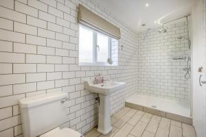 a white tiled bathroom with a sink and a toilet at 2 Bed in Halesworth oc-dak in Halesworth +11 photos