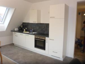 a kitchen with white cabinets and a stove at Herrmanns-Ferienhaus Steigerwald in Schlüsselfeld
