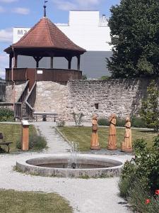 a fountain with three statues of people standing around it at Herrmanns-Ferienhaus Steigerwald in Schlüsselfeld