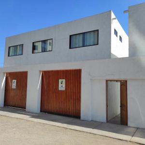 a building with two garages and a red door at Iquique Beachfront -frente a playa Cavancha- in Iquique