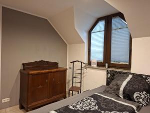 a bedroom with a bed and a dresser and a window at Ferienwohnung im Grünen in Korschenbroich