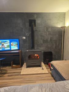 a living room with a stove in front of a wall at Altos Dique Potrerillos in Potrerillos