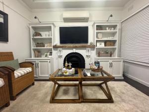 a living room with a coffee table and a fireplace at Pet Friendly Acer Arena Accommodation in Sydney