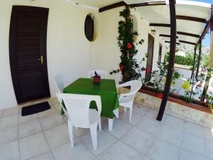 a green table and white chairs on a patio at RESIDENCE 3 STARs SAN VITO LO CAPO in San Vito lo Capo