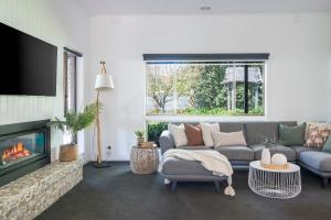 a living room with a couch and a fireplace at The Pool House in Rosebud
