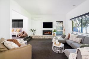 a living room with a couch and a fireplace at The Pool House in Rosebud