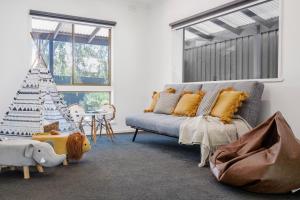 a living room with a couch and a christmas tree at The Pool House in Rosebud