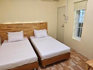 two beds in a small room with white sheets at latitude 14 Room & breakfast in Ban Bang Sakae