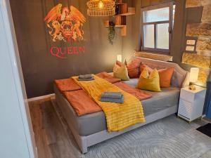 a bedroom with a bed with orange and yellow pillows at Gemütliches Studio in Dresden-zentrumsnah in Dresden